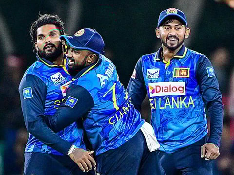 Sri Lanka's captain Charith Asalanka (C) and Wanindu Hasaranga (L) celebrate after taking the wicket of West Indies Roston Chase during the second Twenty20 international at the Rangiri Dambulla International Stadium in Dambulla on October 15, 2024.  