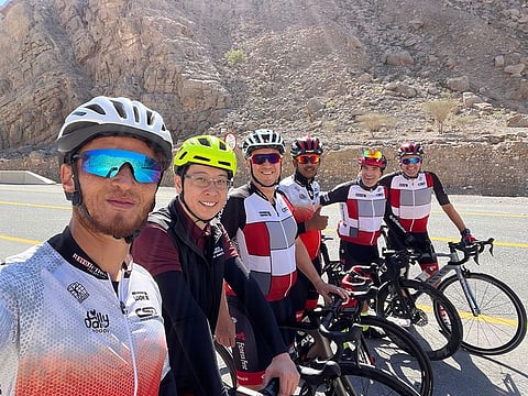Nathan Irvine, with other cycling enthusiasts at the bottom of Jebel Jais after a climb to the top. The cycling community of UAE express their love and passion for the sport, and how it helps them focus on their fitness and well-being. 