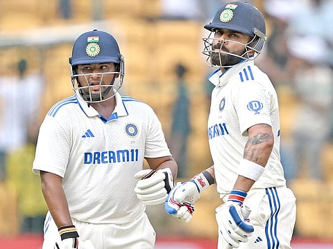 India's Virat Kohli (R) and Sarfaraz Khan bump fists during the third day of the first Test match against New Zealand at the M. Chinnaswamy Stadium in Bengaluru on October 18, 2024.   
