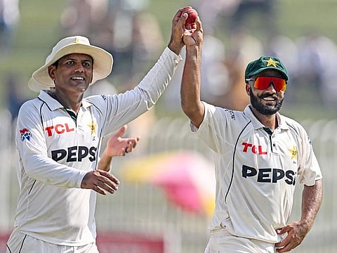 Pakistan's Sajid Khan (R) and Noman Ali celebrate as they walk off the field after end of England's second innings during the third day of the third and final Test match at the Rawalpindi Cricket Stadium in Rawalpindi on October 26, 2024. 