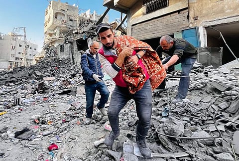 Palestinian remove a body from the rubble of a building hit by an Israeli strike in Beit Lahia, in the northern Gaza Strip, on October 29, 2024.