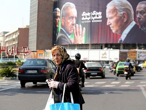 A billboard bearing pictures of Iran's President Masoud Pezeshkian (second left), armed forces chief of staff Major General Mohammad Bagheri (left) US President Joe Biden (second right) and Israeli Prime Minister Benjamin Netanyahu (right) in Vali-Asr square in Tehran on October 27, 2024.  Tehran has long accused Israel of using Iranian agents for covert operations including the assassination of its nuclear scientists.