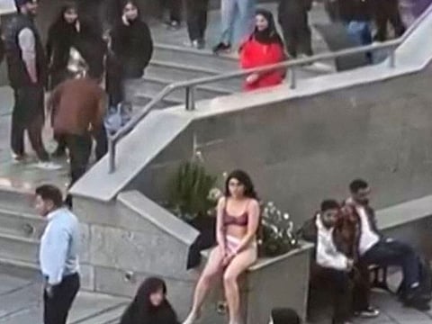  This image grab from a UGC video posted on November 2, 2024, and widely shared on social media shows a female student in her underwear outside Tehran's Islamic Azad University. 