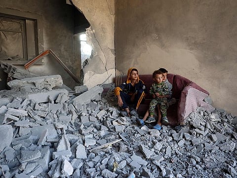 Children sit on a couch amid the destruction following an Israeli strike in the Nuseirat refugee camp in the central Gaza Strip on November 7, 2024, amid the ongoing war between Israel and Palestinian Hamas militants. 