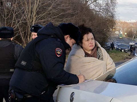 A Russian police officer questions a local resident at site of a drone attack in the village of Stanovoye, Moscow region, on November 10, 2024.  