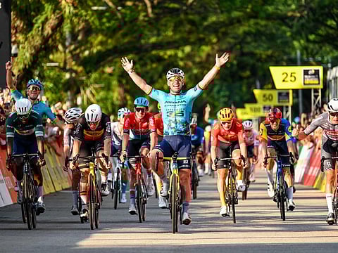 Britain's Mark Cavendish celebrates as he crosses the finish line during the third Tour de France Singapore Criterium race in Singapore on Sunday.
