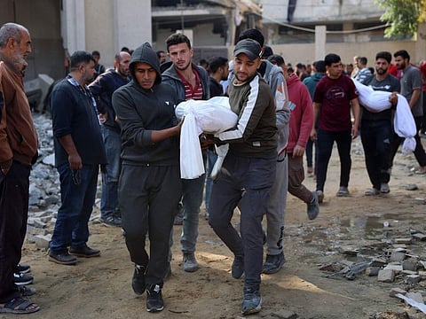 Palestinians carry the bodies of a victims killed in Israeli strikes toward a cemetery in Jabalia in the northern Gaza Strip on November 10, 2024.  