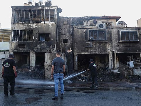 Israeli emergency and security services work clear the site where a rocket fired from Lebanon hit an area in Kiryat Ata a day earlier, in northern Israel's Haifa district on November 12, 2024.   