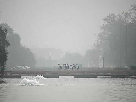 Children walk near India Gate engulfed in smog in New Delhi on November 13, 2024.  