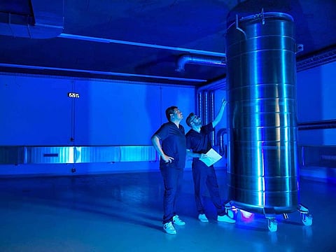 Emil Kendziorra (R), CEO of Tomorrow Biostastis, and a fellow employee in their 'storage space' with a container to store human bodies at the company's premises in Rafz, Switzerland.