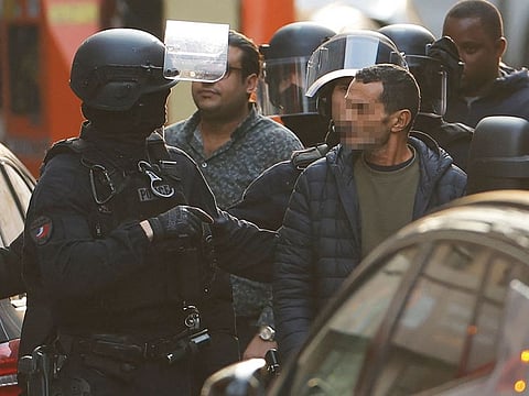 A hostage is accompanied by a police officer after being released from the restaurant ‘Pizza L'Olivier’ in Issy-les-Moulineaux, suburbs of Paris, on November 16, 2024. 