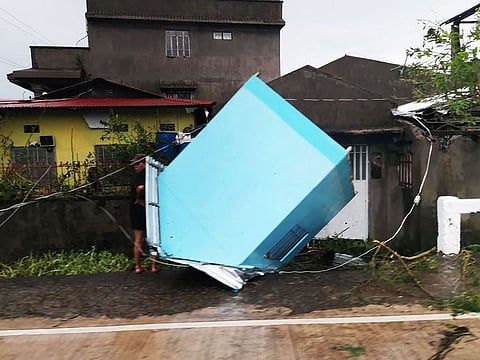 A resident standing next to a blown off kiosk along a street in Panganiban town, Catanduanes province.