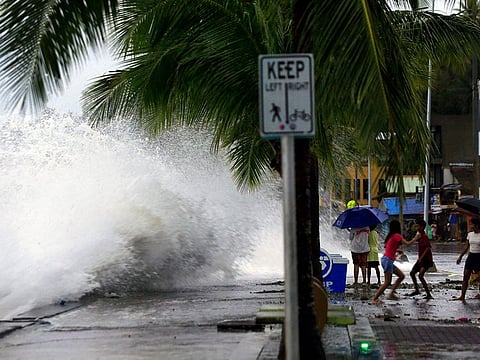 People react as large waves break along a seawall ahead of the expected landfall of Super Typhoon Man-yi, in Legaspi City, Albay province on November 16, 2024. 