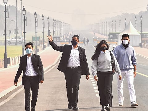 People wearing masks walk along Kartavya Path amid heavy smog as the air quality remains in the 'severe' category in New Delhi on Wednesday, November 20, 2024. 