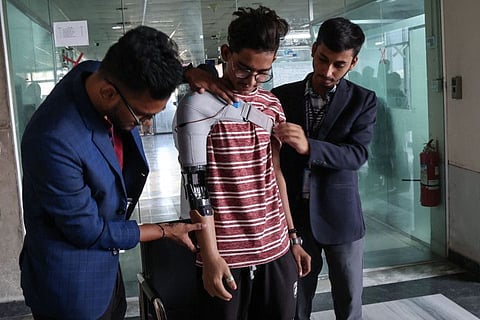 A protester who lost his arm in July's students' revolution tries out a prosthetic arm manufactured by Robolife Technologies in Dhaka on November 21, 2024.  