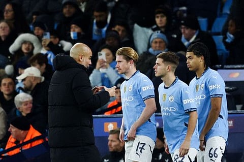 Manchester City's Spanish manager Pep Guardiola (left) speaks to midfielder Kevin De Bruyne, James McAtee and Jahmai Simpson-Pusey during the Uefa Champions League football match against Feyenoord at the Etihad Stadium in Manchester, north west England, on Tuesday.