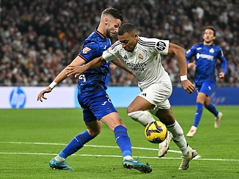 Real Madrid's French forward  Kylian Mbappe fights for the ball with Getafe's Portuguese defender Domingos Duarte during the Spanish league football match in Madrid on Sunday.