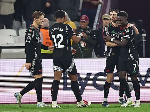 Arsenal's English midfielder Bukayo Saka celebrates with teammates after scoring their fifth goal from the penalty spot during the English Premier League football match against West Ham United.