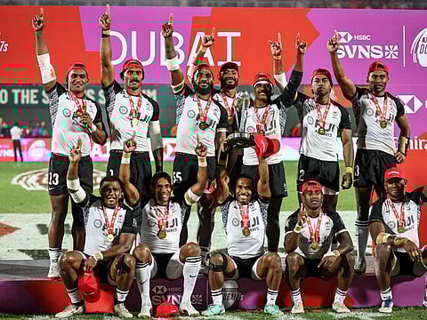 Fiji's players celebrate on the podium after winning the the HSBC World Rugby Sevens Series men's final rugby match against Spain at the Sevens Stadium in Dubai on Sunday.