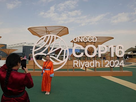 Delegates take pictures outside the conference centre where the United Nations Convention to Combat Desertification, UNCCD COP16, was opened in the Saudi capital Riyadh on December 2, 2024.  