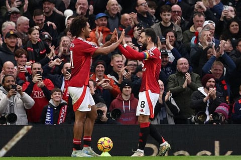 Manchester United's Dutch striker Joshua Zirkzee (left) celebrates with Portuguese midfielder Bruno Fernandes after scoring thier fourth goal during the English Premier League football match against Everton at Old Trafford in Manchester, north west England, on December 1.