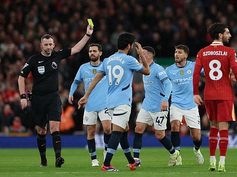 English referee Chris Kavanagh shows a yellow card to Manchester City's English midfielder Phil Foden during the English Premier League football match against Liverpool at Anfield in Liverpool, north west England on December 1.