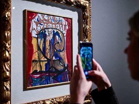 A visitor takes pictures of an illustration for Romeo and Juliet by Spanish artist Salvador Dali during a press preview of the exhibition titled "SalvArti, from Confiscations to Public Collections" at Palazzo Reale in Milan, Italy, on December 2, 2024. The exhibition, running from December 3, 2024 to January 26, 2025, showcases a series of contemporary artworks coming from confiscations carried out by public authorities against organised crime. (Photo by Piero CRUCIATTI / AFP) / RESTRICTED TO EDITORIAL USE - MANDATORY MENTION OF THE ARTIST UPON PUBLICATION - TO ILLUSTRATE THE EVENT AS SPECIFIED IN THE CAPTION