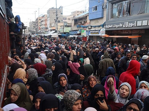 Palestinians wait for bread outside a bakery in the Nuseirat camp in central Gaza on November 27, 2024, amid the ongoing war in the Palestinian territory between Israel and Hamas.  