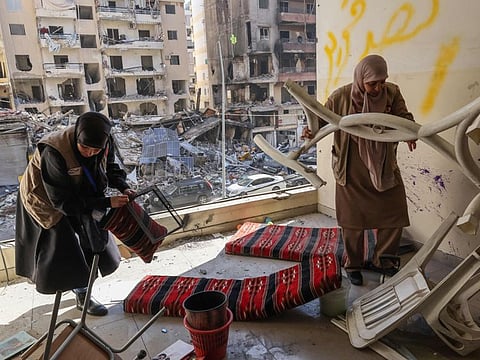 Staff members of the Amel Association, a Lebanese non-governmental organisation, salvage items at their branch that was damaged in an Israeli strike on a nearby building, in Beirut's southern suburbs Hay Al Sellom neighbourhood on December 2, 2024.  