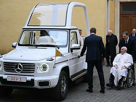 Pope Francis looks on as he's presented a new fully electric popemobile, at the Vatican.