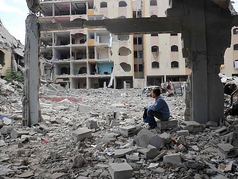 A Palestinian boy sits amid the destruction as displaced residents return to Nuseirat in the central Gaza Strip after Israeli shelling of the camp stopped on November 29, 2024.