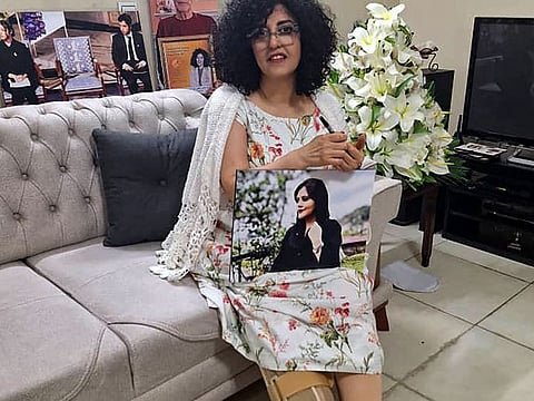 A handout picture provided by the Norwegian Nobel Committee on December 4, 2024, shows peace prize winner Nargis Mohammadi holding a picture of Iranian Kurdish woman Mahsa Amini, who died in custody in Iran, at at unknown location and unspecified date.  