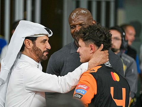  McLaren's British driver Lando Norris is greeted by FIA president Mohammed Ben Sulayem (L) and US actor Terry Crews after taking the pole position at the end of the qualifying session ahead of the Abu Dhabi Formula One Grand Prix at the Yas Marina Circuit in Abu Dhabi on December 7, 2024.