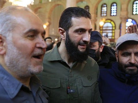 People pose for a picture with Abu Mohammed Al Jolani (centre), the leader of Syria's Islamist Hayat Tahrir Al Sham (HTS) group that headed a lightning rebel offensive snatching Damascus from government control, before his address at the capital's landmark Umayyad Mosque on December 8, 2024.  