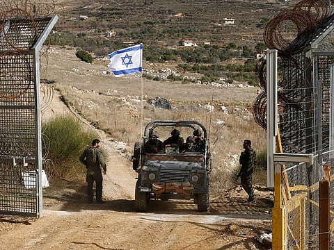 An Israeli military vehicle crosses the fence as they return from the buffer zone with Syria, near the Druze village of Majdal Shams in the Israel-annexed Golan Heights, on December 10, 2024.   