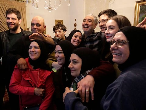 Moaz Merheb (centre-right), 51, is received by his family and friends after 18 years of imprisonment in Syria's notorious Saydnaya prison, in Lebanon's northern port city of Tripoli, on December 10, 2024.  