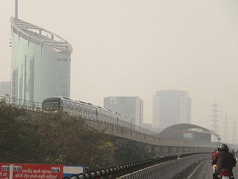Rapid metro makes its way amid fog, in Gurugram.