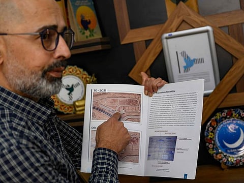 Riyad Avlar, who co-founded the Association of Detainees and Disappeared Persons of Saydnaya Prison (ADMSP), displays a research booklet about Saydnaya in Gaziantep, on December 11, 2024.  