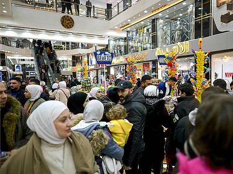 People shop at a shopping mall in the town of Al Dana, near Sarmada, in the northern Syrian province of Idlib on December 13, 2024. The crowd wanders in awe through the aisles saturated with lights, dazzled by the abundance of goods displayed before them in the heart of the former rebel stronghold. 