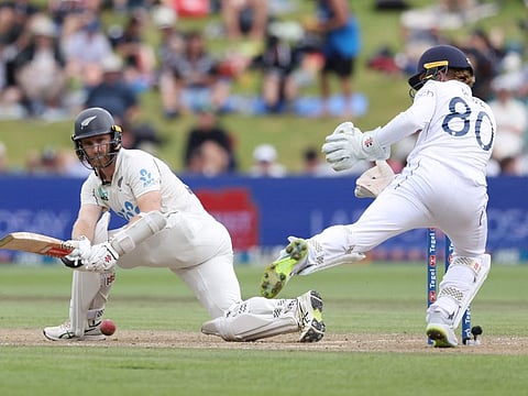 New Zealands Kane Williamson sweeps while being watched by England wicketkeeper Ollie Pope on day three of the third cricket Test match at Seddon Park in Hamilton on Monday.