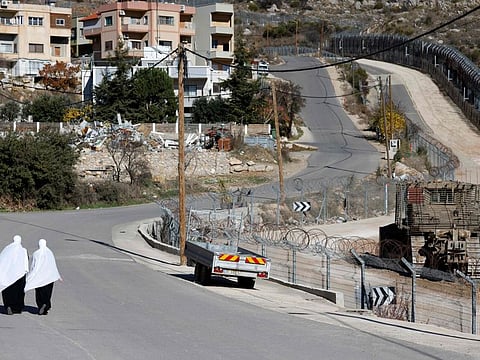 Druze women walk near the fence leading into the UN-patrolled buffer zone, which separates Israeli and Syrian forces on the Golan Heights, near the Druze village of Majdal Shams in the Israel-annexed Golan Heights on December 15, 2024.  