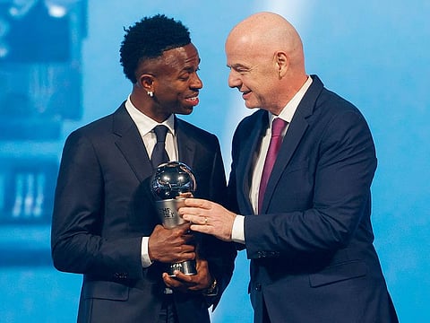 Brazilian forward Vinicius Junior (L) receives the Best Player trophy from FIFA President Gianni Infantino during the Best FIFA Football Awards 2024 ceremony in Doha on December 17, 2024. 