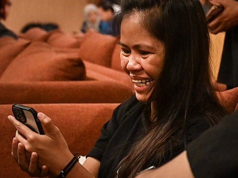 Filipina inmate on Indonesia death row, Mary Jane Veloso speaks on a phone as she arrives at the Soekarno-Hatta International Airport in Tangerang on December 17, 2024, for her repatriation to Philippines.  