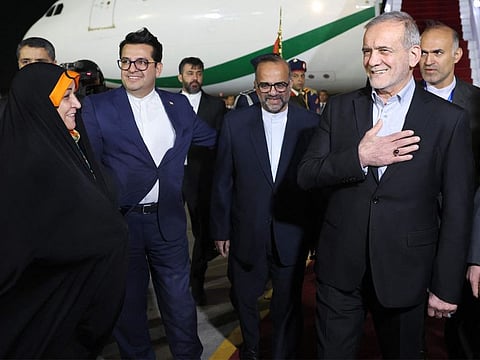 Iran's President Masoud Pezeshkian (right) being received after disembarking his aircraft upon arrival at Cairo International Airport on December 18, 2024 to attend the D-8 summit. 
