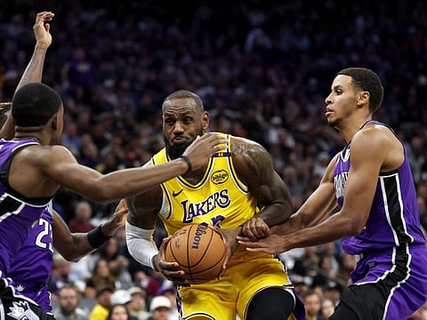 LeBron James (centre) of Los Angeles Lakers is guarded by Keegan Murray and De'Aaron Fox of Sacramento Kings in the second half at Golden 1 Center on Thursday.