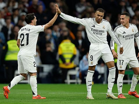 Real Madrid's Moroccan forward Brahim Diaz (left) celebrates with forward Kylian Mbappe scoring his team's fourth goal during the Spanish league football match against Sevilla FC at the Santiago Bernabeu stadium in Madrid on Sunday.