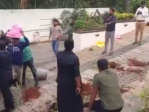  A group stormed into his house, hurling tomatoes and smashing flower pots.