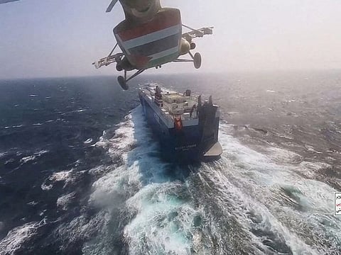 Al Houthi military helicopter flies over the Galaxy Leader cargo ship after it seized the vessel in the Red Sea in November.  
