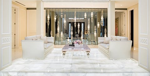 The entrance hall leads to this chic lounge area, elevated on illuminated white onyx. Only one of the columns is structural and the other three were added to create the illusion of symmetry in the space