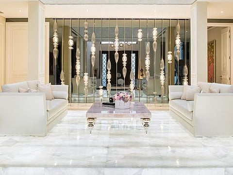 The entrance hall leads to this chic lounge area, elevated on illuminated white onyx. Only one of the columns is structural and the other three were added to create the illusion of symmetry in the space
